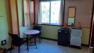 Una habitación con una mesa y sillas y una ventana. en Mango House Apartments, en Panglao