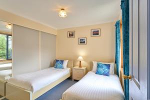 two beds in a room with a window at Bicheno Bliss in Bicheno