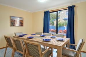 a dining room with a wooden table and chairs at Bicheno Bliss in Bicheno +13 photos