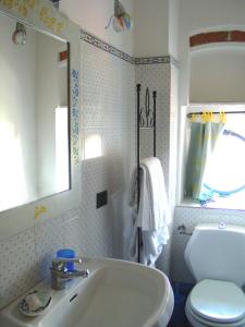 a bathroom with a sink and a toilet and a mirror at Vecchia Locanda in Sarzana