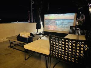 館山的住宿－OCEAN FRONT TATEYAMA - Vacation STAY 37303v，一间设有屏幕、椅子和桌子的房间