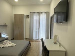 a bedroom with a bed and a table and a window at La Rondine Bed in Ficarazzi