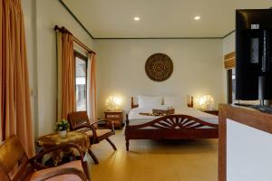 a bedroom with a bed and a television in it at The Bay Samui in Choeng Mon Beach +33 photos
