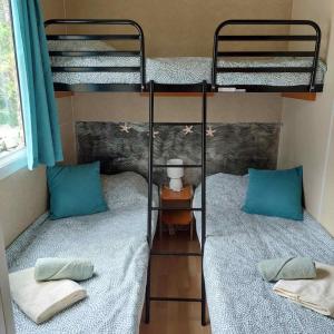 2 Etagenbetten mit blauen Kissen in einem Zimmer in der Unterkunft Little house in Ražanac in Ražanac
