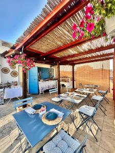 eine Terrasse mit Tischen, Stühlen und Blumen in der Unterkunft Hotel Posta in Syrakus