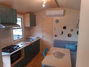 eine Küche mit grünen Schränken und einem Tisch darin in der Unterkunft Little house in Ražanac in Ražanac