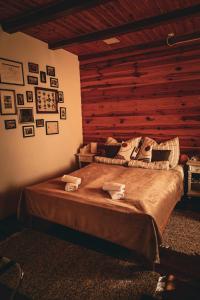1 dormitorio con 1 cama grande y pared de madera en Kisház Apartman en Eger