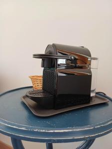 Czarny toster siedzący na niebieskim stole w obiekcie Casa Silvia w mieście Bracciano