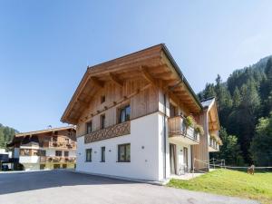 a large white building with a wooden roof at Chalet in Saalbach near Ski Lift in Saalbach-Hinterglemm