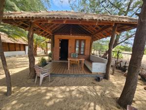 un pabellón de madera con mesa y banco en Eco village beach resort, en Pottuvil