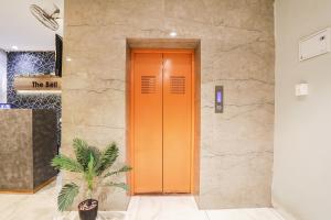 an orange door in a building with a plant at FabHotel The Bell in Bhilai