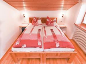 una camera con due letti con cuscini rossi e bianchi di Pleasant Apartment in Ruhpolding with Swimming Pool a Ruhpolding