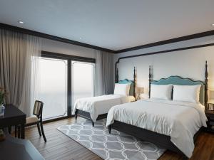 a bedroom with two beds and a large window at Aquarius Premium Hotel in Hanoi
