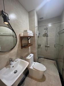 a bathroom with a toilet and a sink and a shower at Vida Loca Sunset Beach Resort in Phu Quoc