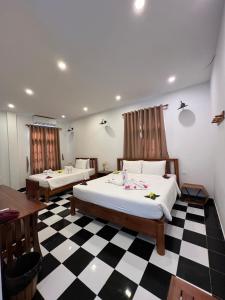 two beds in a room with a checkered floor at Vida Loca Sunset Beach Resort in Phu Quoc