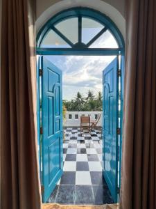 an open door to a patio with a checkered floor at Vida Loca Sunset Beach Resort in Phu Quoc