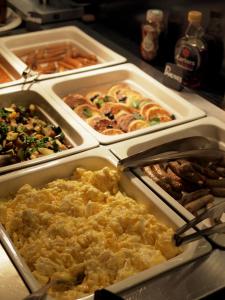 um buffet de diferentes tipos de alimentos em bandejas em Theresian Hotel em Olomouc