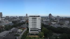a tall white building in the middle of a city at Brits Hotel Puri Indah in Jakarta