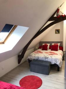 una camera mansardata con letto e tappeto rosso di Un coin de paradis a Montpollin