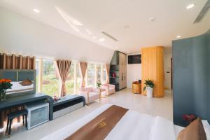 uma grande sala de estar com uma cama e um sofá em Quy Tai Premium Hotel em Da Lat