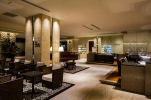 a lobby of a hotel with a piano and tables at Hotel Shigira Mirage in Miyako Island