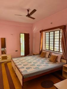 Schlafzimmer mit einem großen Bett und einem Fenster in der Unterkunft JWALA JAIPUR in Jaipur