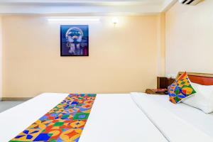 sypialnia z łóżkiem z kolorowym kocem w obiekcie FabHotel Oasis w mieście Mātigara