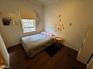 um pequeno quarto com uma cama e uma janela em Chimu Home-Hostel em Perth
