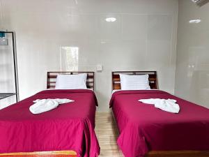 two beds with white towels on them in a room at MJ RESORT in Nong Phai