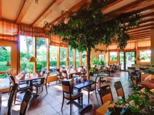 a restaurant with tables and chairs and windows at Holiday apartment on the golf course F35E in Fehmarn