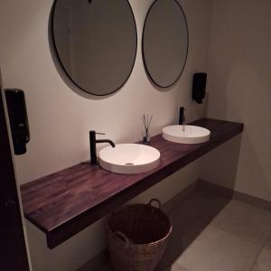 a bathroom with two sinks and two mirrors at Hotell Toftalund in Halmstad