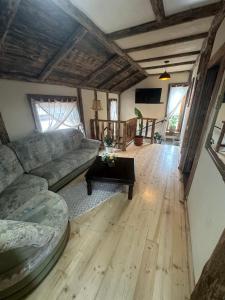 a living room with a couch and a table at Hanul Bărăției in Câmpulung