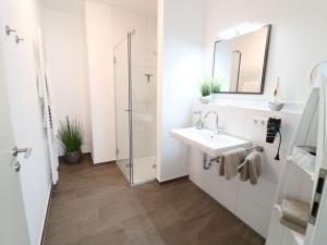 Un baño blanco con lavabo y espejo. en Sea eagle in the Molenhuus, en Kappeln 34 fotos más