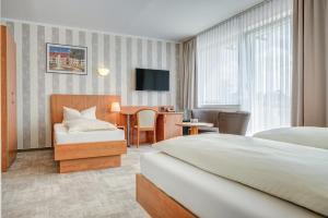 ein Hotelzimmer mit einem Bett und einem Schreibtisch in der Unterkunft Hotel Wilna in Erfurt