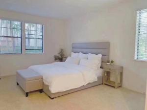 a white bedroom with a large white bed and windows at 3 Bedrooms Apt with Pool ,GYM in Irvine +4 photos