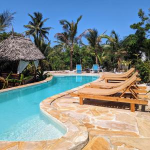una piscina con tumbonas y un complejo en Lala Land Lodge, en Kizimkazi