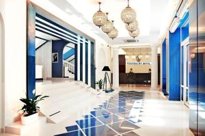 a lobby with blue walls and a black and white tile floor at Teatralny Hotel in Zaporozhye