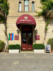 een restaurant met een rode luifel boven de deur bij Shah Palace Luxury Museum Hotel in Baku