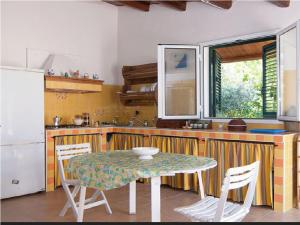 カヴァ・ダリーガにあるSerenity Holiday Homeのキッチン(テーブル、椅子、テーブル、冷蔵庫付)