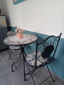 a table and two chairs with a flower pot on it at Zoom Garden Home in Nonthaburi