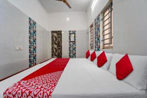 - une chambre avec un grand lit et des oreillers rouges dans l'établissement OYO Pothini Palace, à Palni