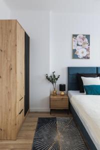 sypialnia z dużym łóżkiem i drewnianą szafką w obiekcie Toka City Centrum w Szczecinie