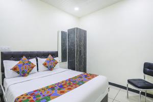 1 dormitorio con 1 cama y 1 silla en FabExpress Sai Palace, en Raipur