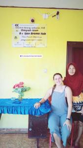 Dos mujeres sentadas en una mesa en una habitación en IjenBromo Hub Omyah Isun Hub, en Ketapang
