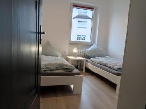 a small room with two beds and a window at Work and Stay 6 Zimmer 150qm 12 Betten 3 Badezimmer in Meinerzhagen