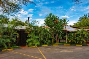 a parking lot in front of a building with palm trees at Hotel Boulevard Nairobi, City Centre CBD in Nairobi