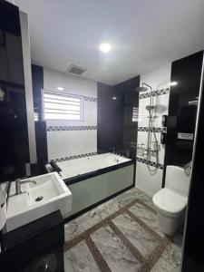 a bathroom with a tub and a sink and a toilet at H&H Homestay Premium House in Kepala Batas