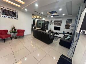 a living room with couches and chairs and a kitchen at H&H Homestay Premium House in Kepala Batas