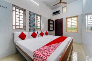 una camera da letto con un grande letto con cuscini rossi di OYO Pothini Palace a Palni