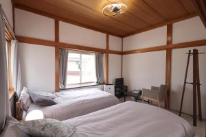 1 dormitorio con 2 camas y ventana en くつろぎのお宿 やわや toyama en Sakurabashidōri